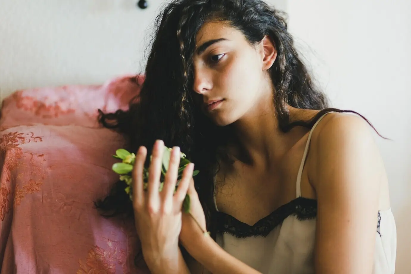 Junge Brünette hält zerbrechliche Blumen.